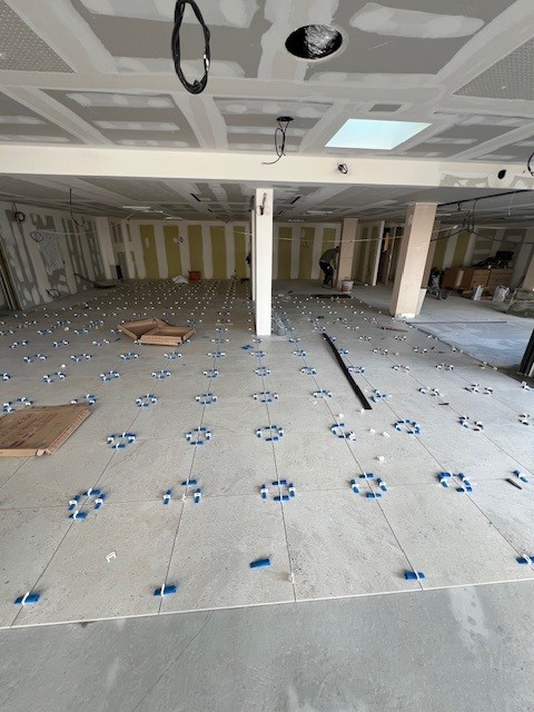 Pose de carrelage en cours sur chantier commercial